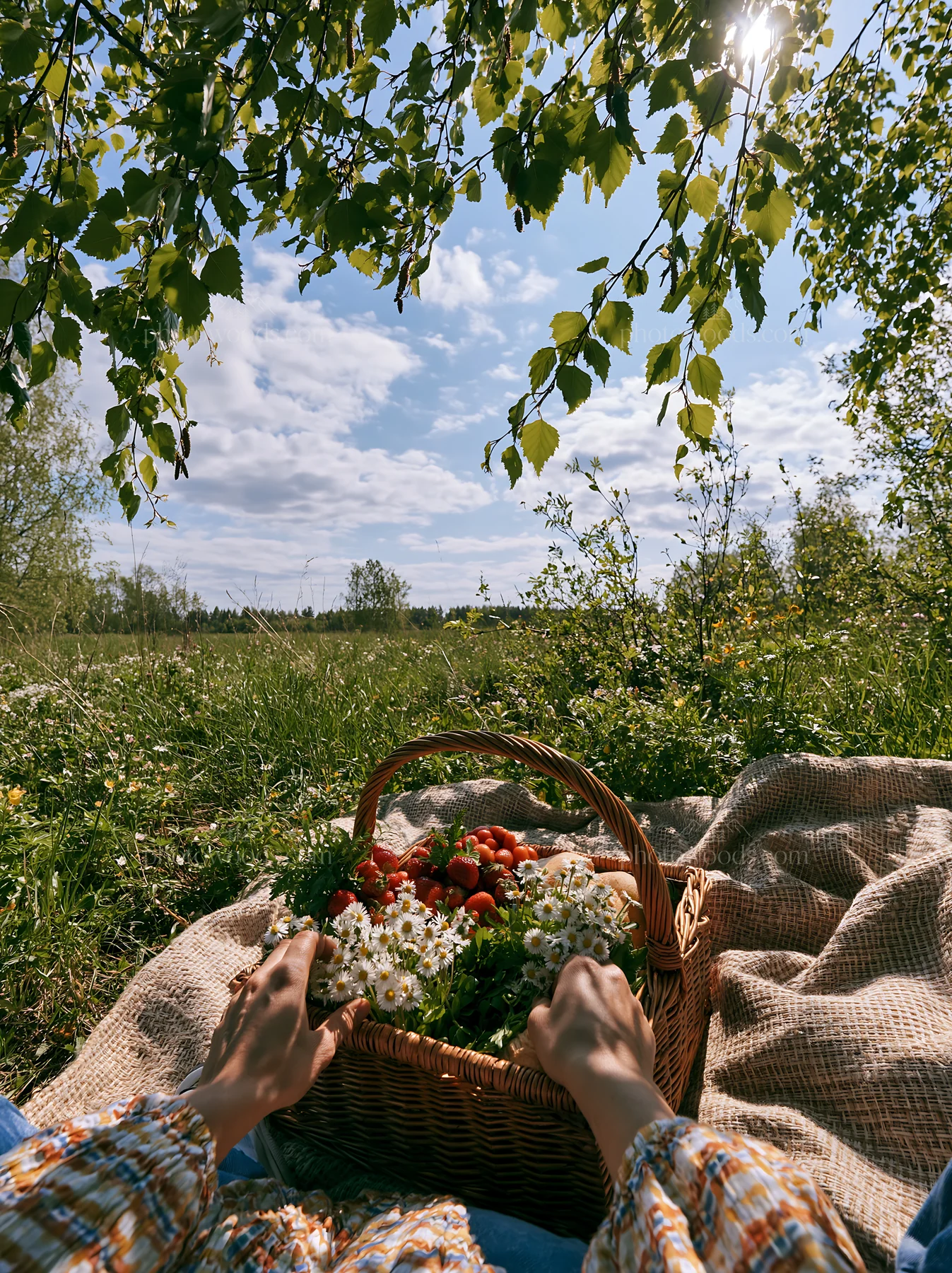 Easter basket in a meadow with flowers and strawberries - AI-generated stock image
