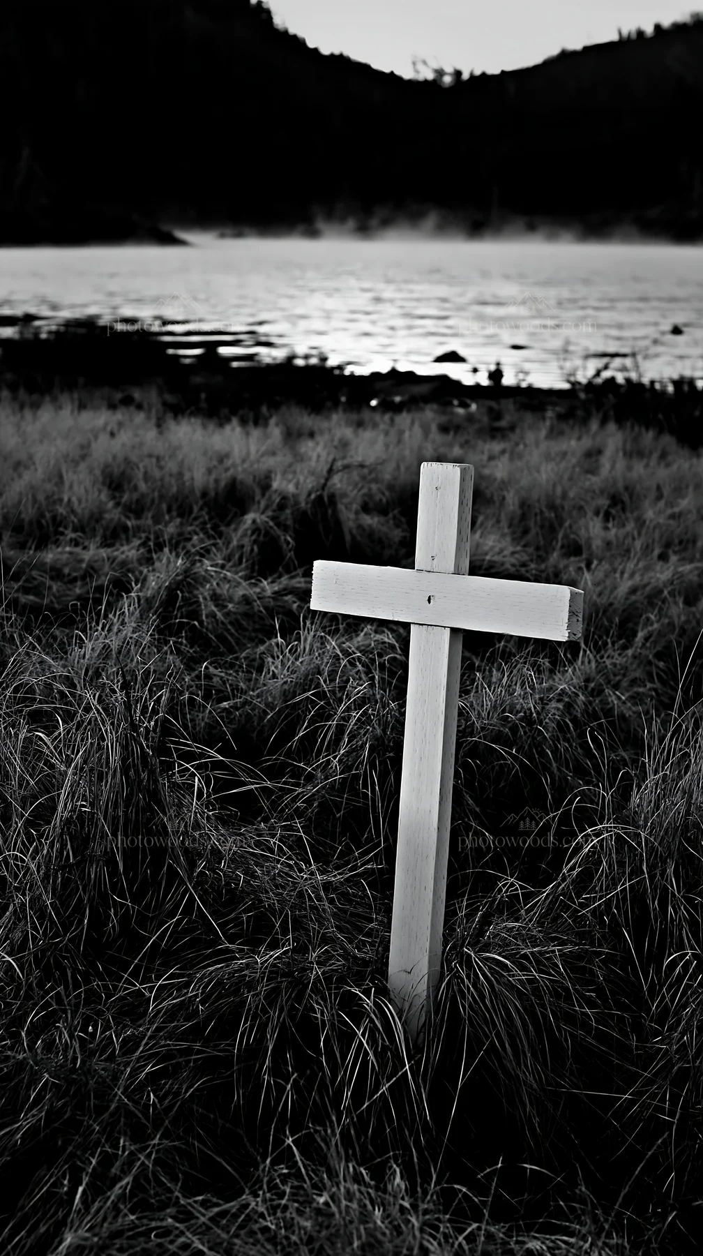 White Christian cross in remote meadow by water - AI-generated stock image