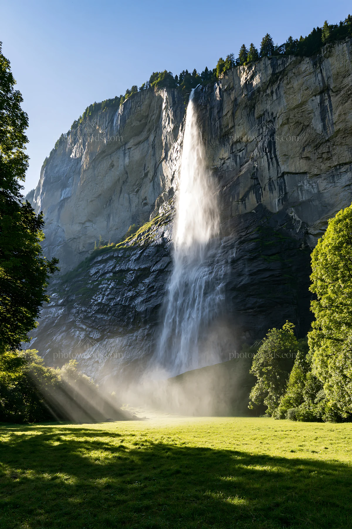 Light rays shining on meadow in Lauterbrunnen Valley - AI-generated stock image