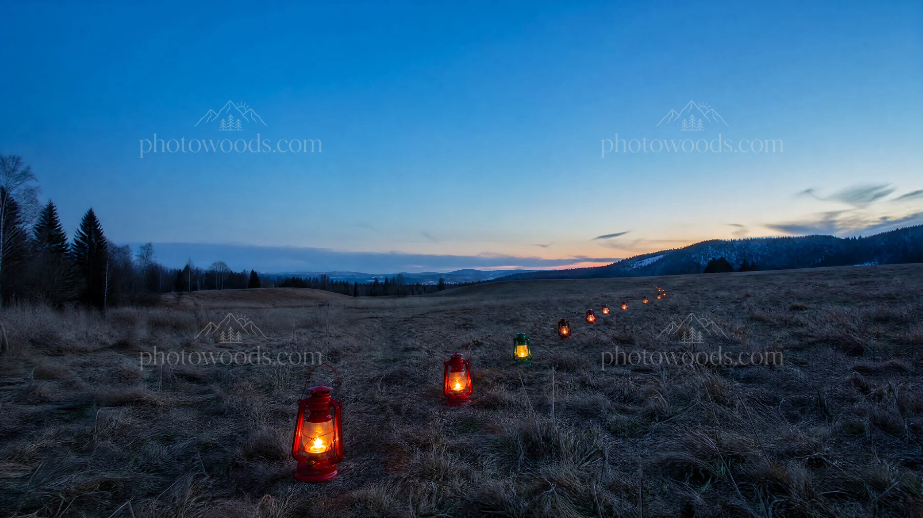 Colorful lanterns in a meadow at dusk - AI-generated stock image