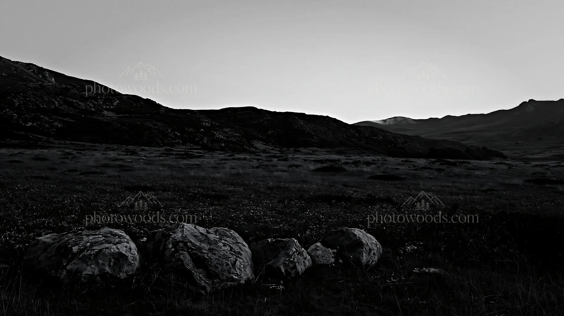 Meadow with boulders and mountains at dusk - AI-generated stock image
