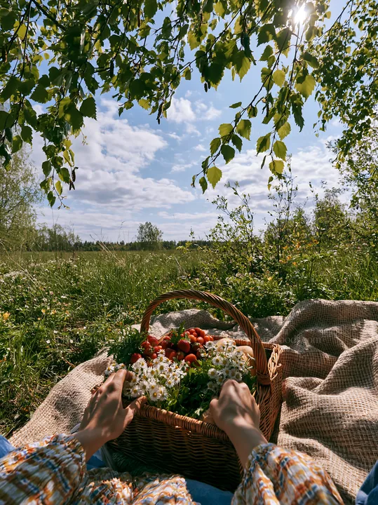 Easter basket in a meadow with flowers and strawberries - AI-generated stock image