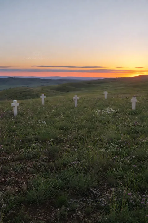 Christian crosses on meadow at sunrise with light rays - AI-generated stock image