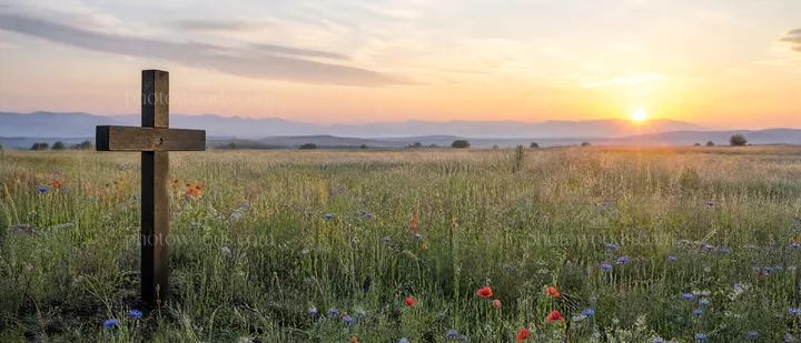 Wooden Christian cross in meadow at sunrise with light rays - AI-generated stock image