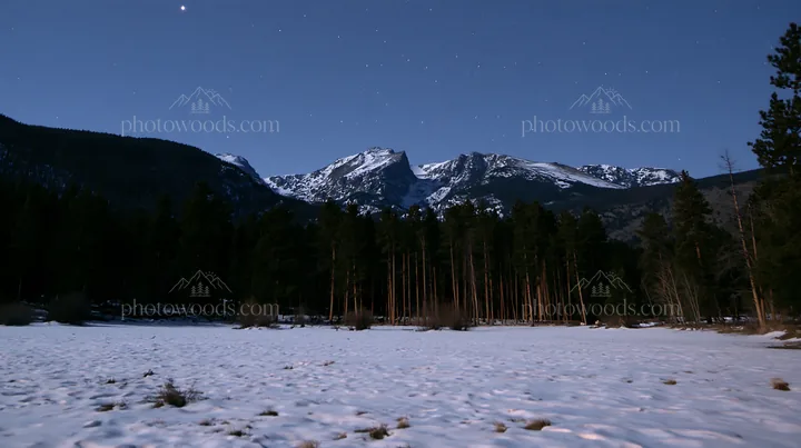 Snowy Rocky Mountain Park meadow under the night sky - AI-generated stock image