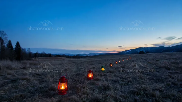 Colorful lanterns in a meadow at dusk - AI-generated stock image
