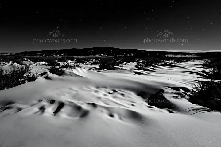 Snowdrift meadow under night sky with distant mountains - AI-generated stock image