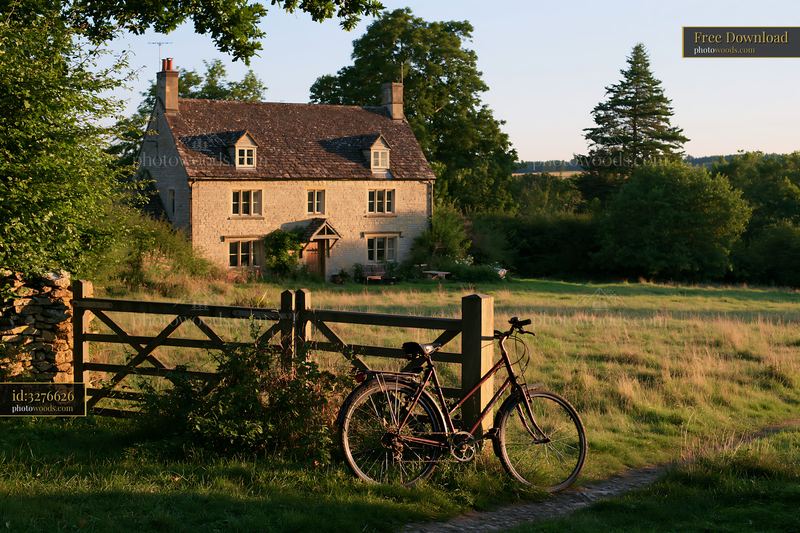 Country home with bicycle outside in green landscape