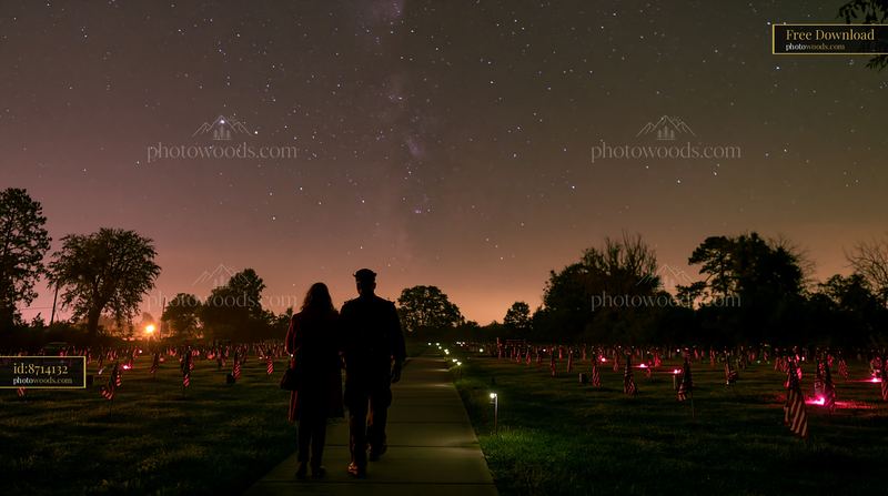 Patriotic cemetery scene under a starry sky with two figures