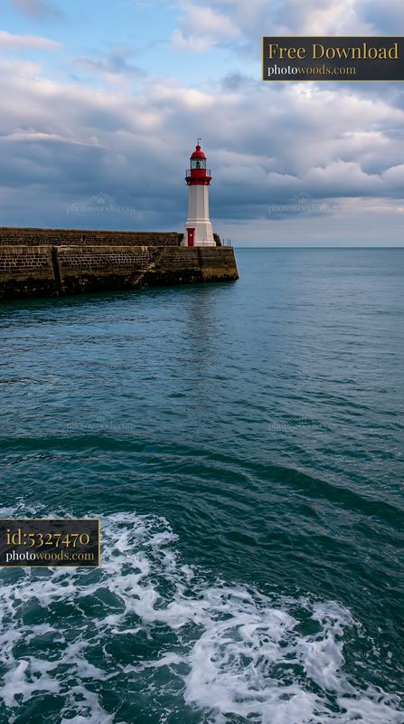 Lighthouse on the shore with a cloudy sky above
