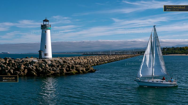 Lighthouse with boats in the foreground near the coast