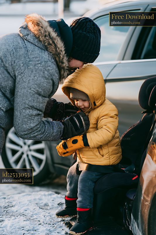 Preparing a child for winter holiday road trip in a car