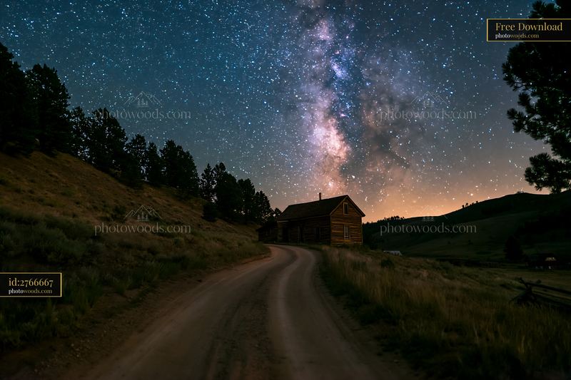 Remote house under Milky Way and winding dirt road