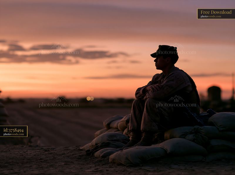 Soldier silhouette at dawn resting on sandbags