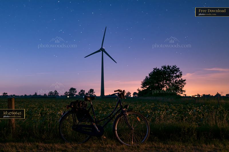 Starry night view with a rural wind turbine and bicycle foreground