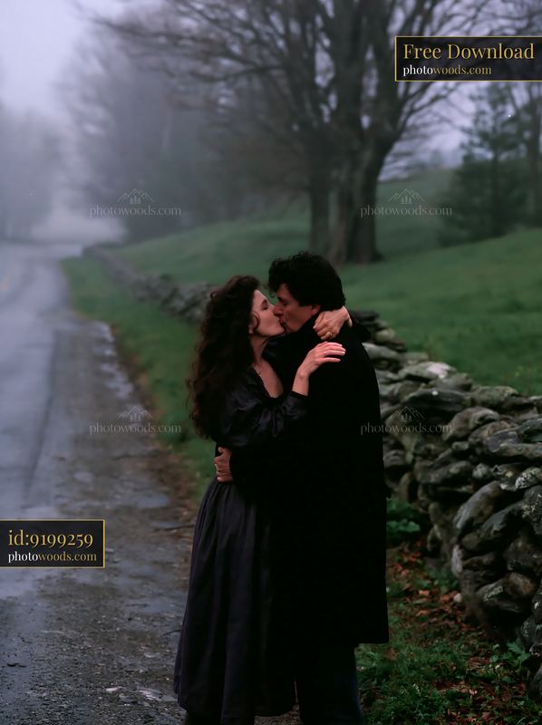 Couple kissing beside a misty country road