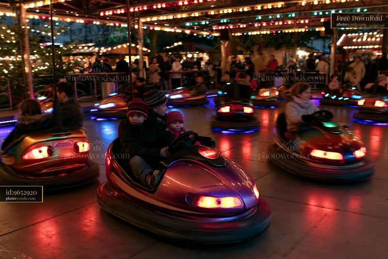 Family riding bumper cars at a brightly lit amusement ride