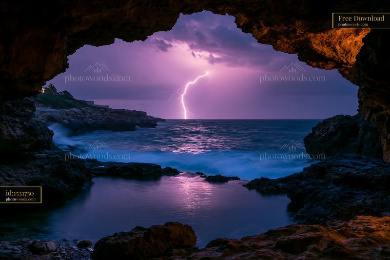 Lightning over ocean viewed from a rocky sea cave
