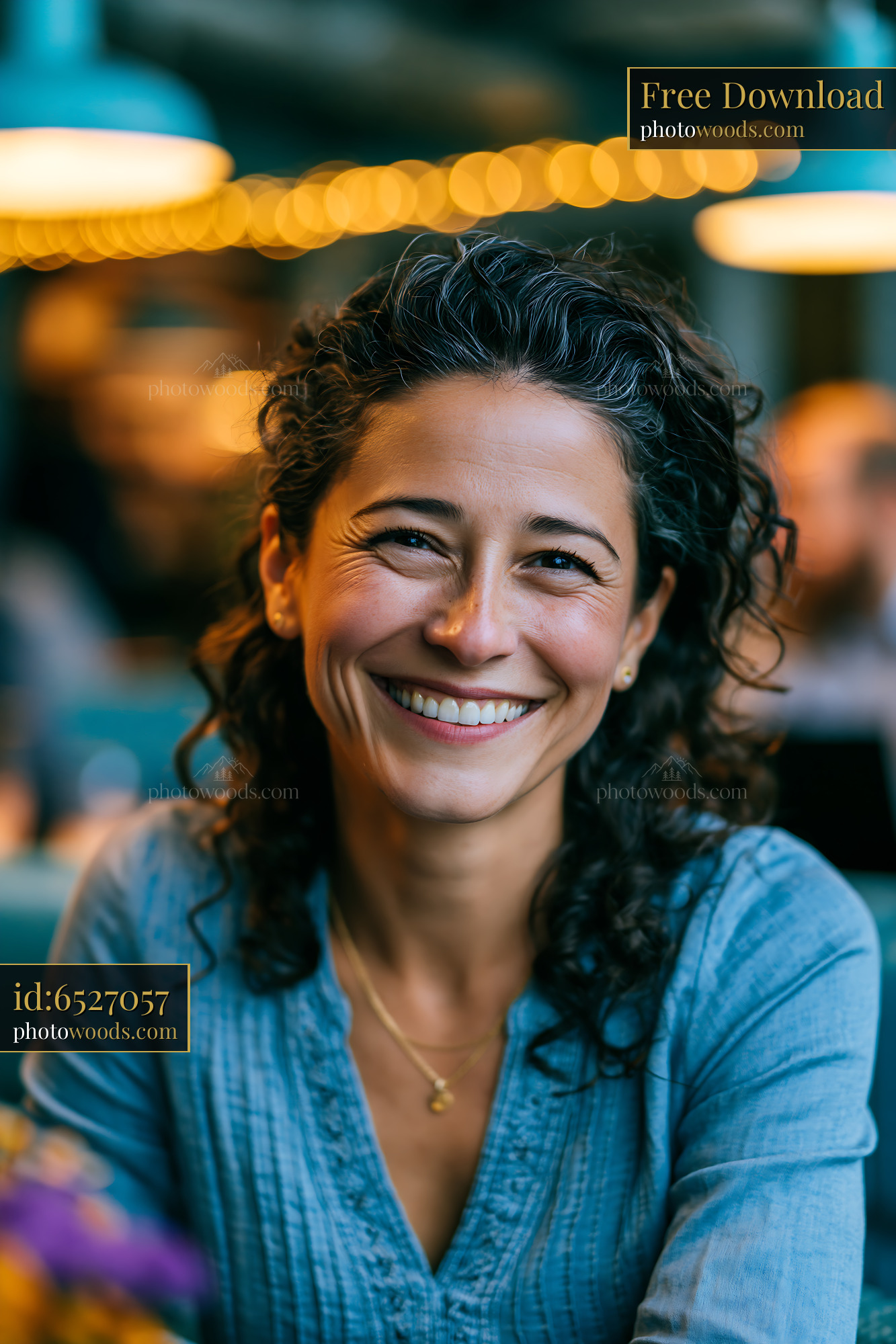 Woman Smiles Warmly While Sitting at a Table in a Cafe