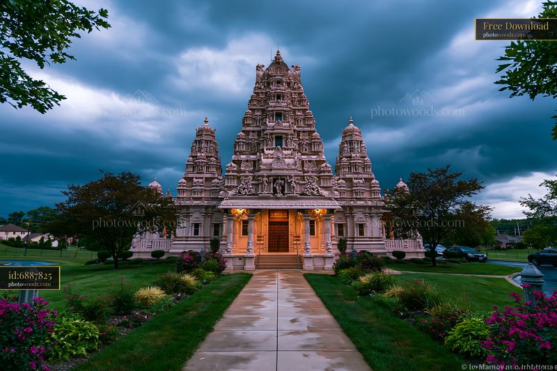 Ornate Hindu temple facade beneath dramatic storm clouds