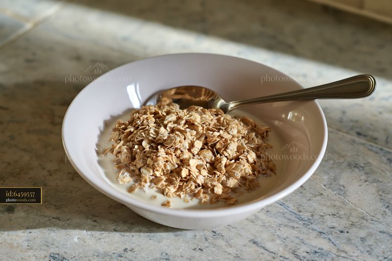 Cream dose with oat flakes in a bowl on a kitchen countertop