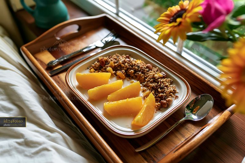 Breakfast plate with muesli and fresh fruit on a wooden tray