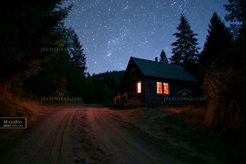 Isolated cabin under a starry sky with a quiet dirt road