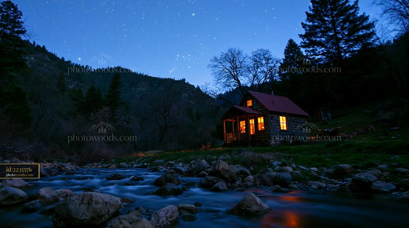 Cabin beside a stream with stars in the night sky