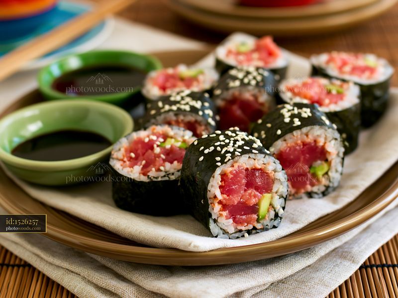 Close-up of fresh spicy tuna roll served with dipping sauces