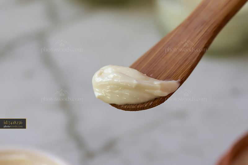 Cream dose with matte texture on a wooden spoon