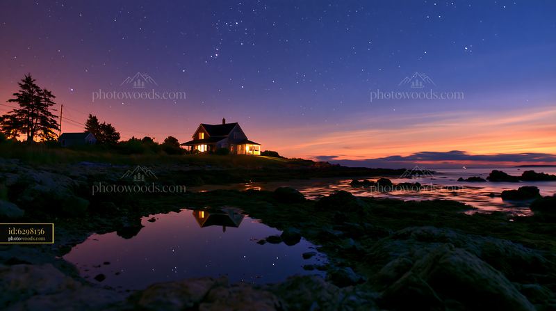 Coastal home near ocean horizon under stars at twilight