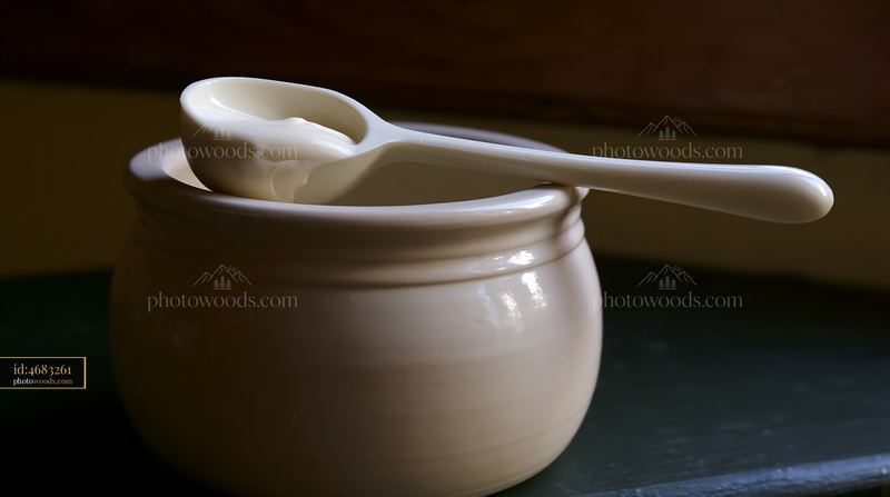 Cream dose measured with a cosmetic scoop in a small bowl