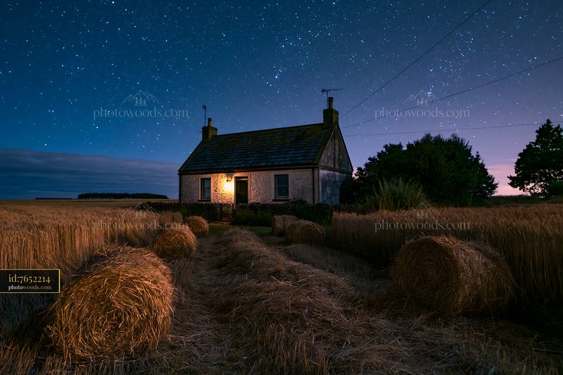 Cottage under stars in a rural setting at night