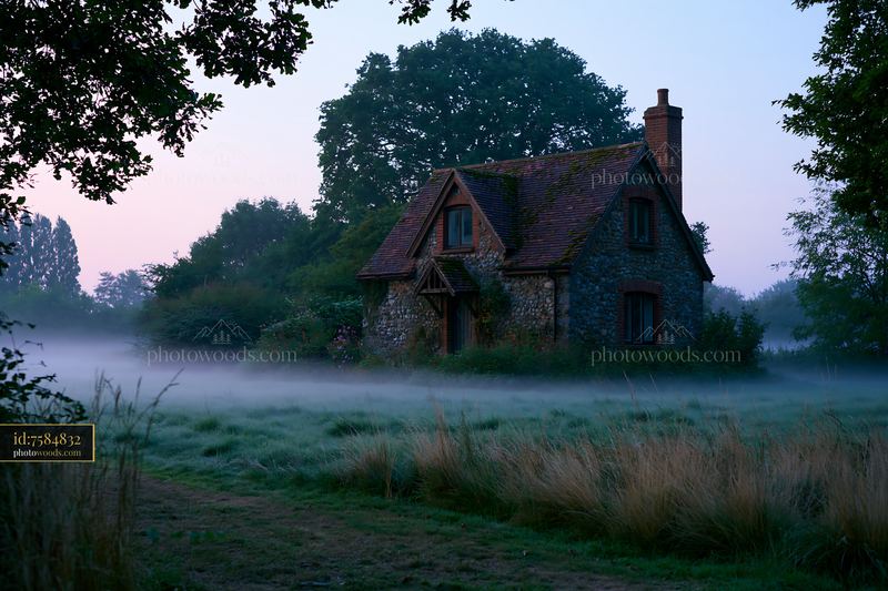 Misty countryside around cottage at dawn