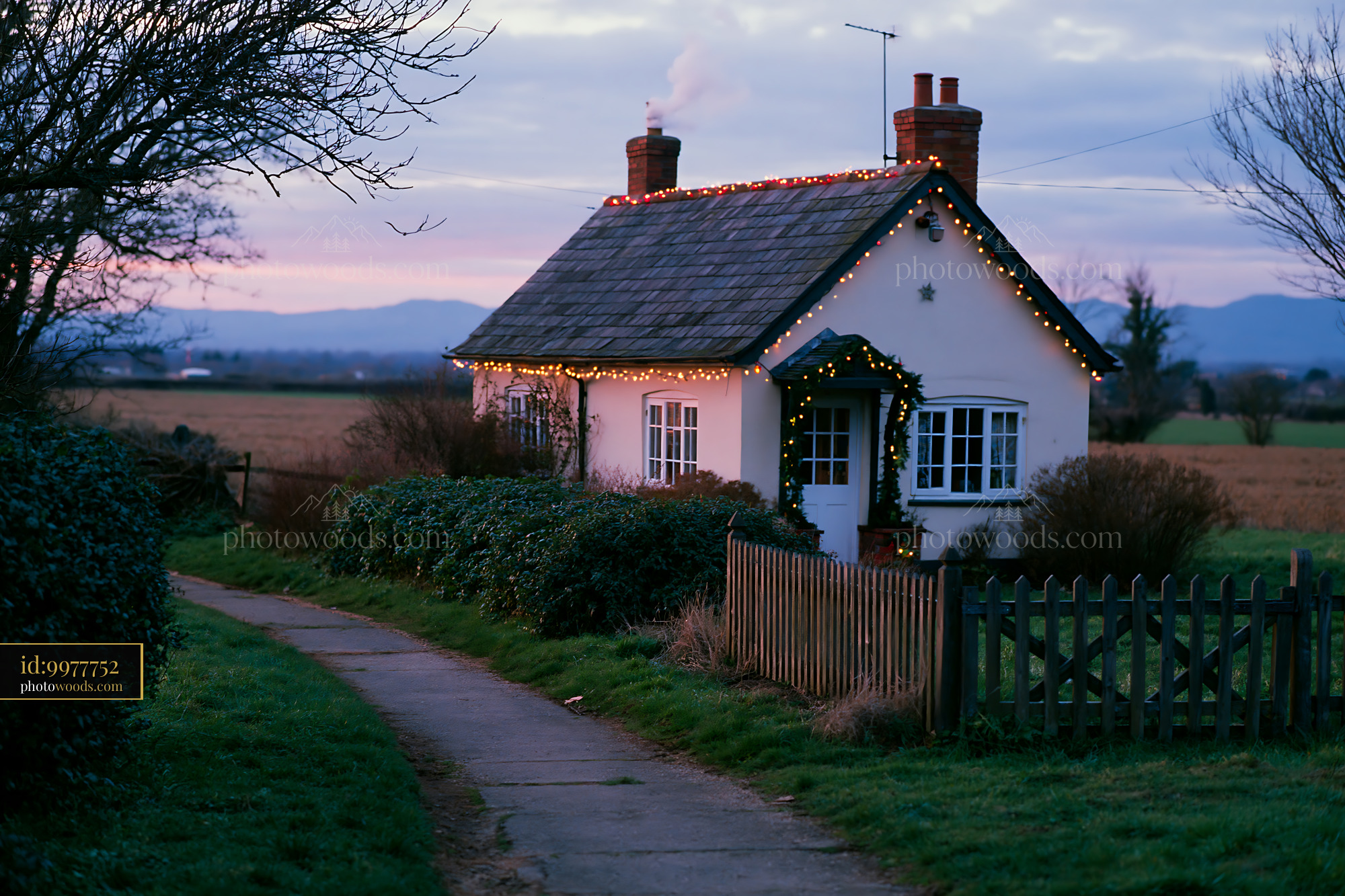 A country cottage with Christmas decorations is seen at dusk.