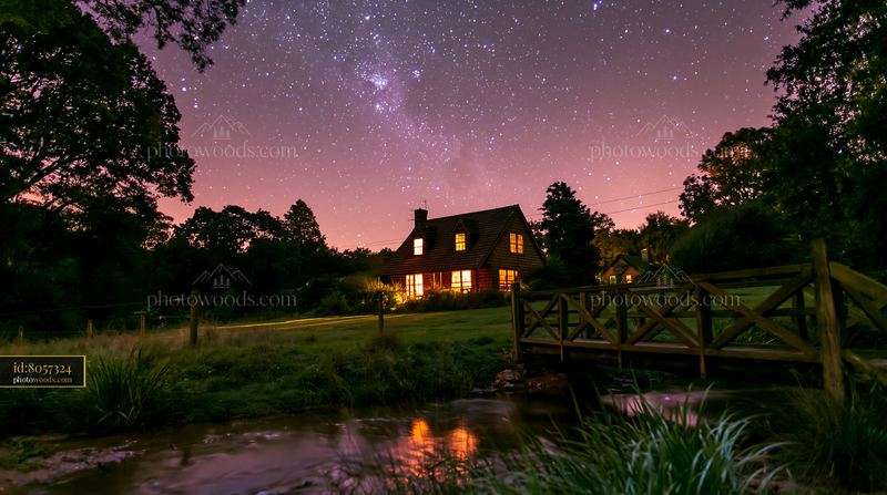 Country house beneath starry sky with visible stars and water