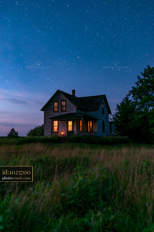 Country house illuminated at night under a starry sky