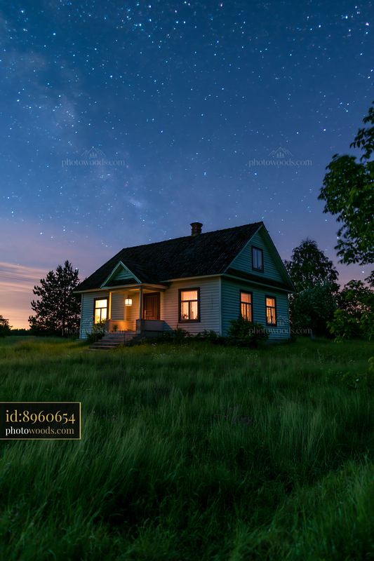 Country house under starry sky in open field