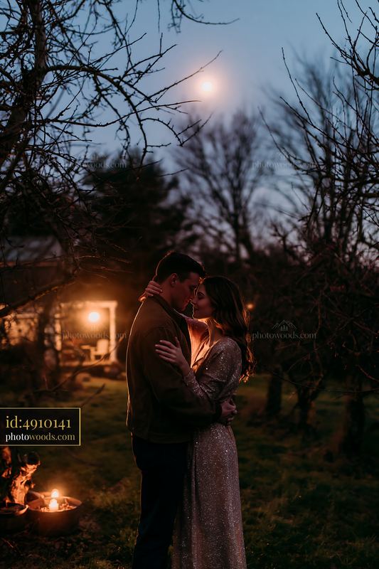 Couple embracing under a starry sky in a garden at night