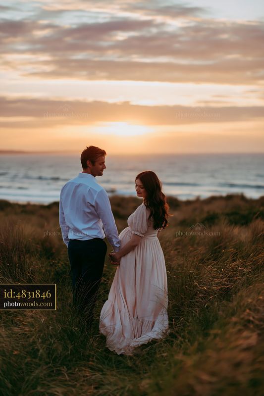Couple standing together at sunset by the beach