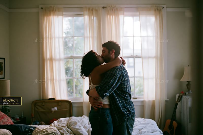 Couple kissing in bright bedroom with natural light