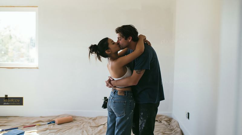 Couple kissing in bright bedroom during home renovation