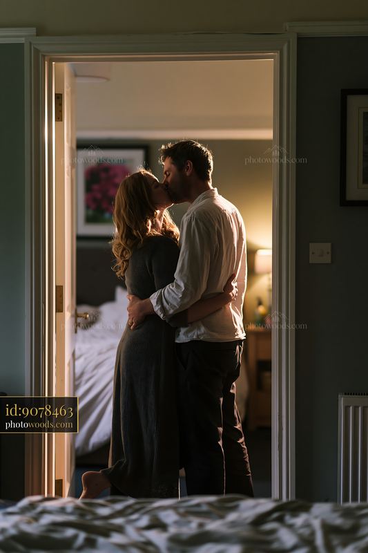 Couple kissing in home doorway before leaving for work