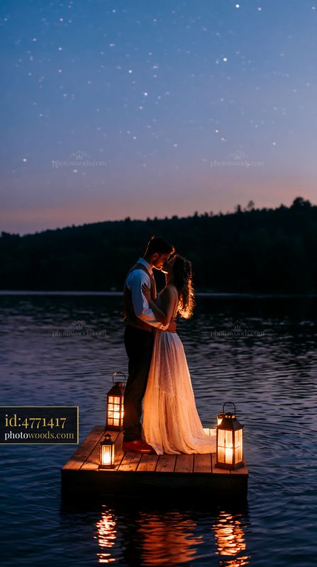 Couple shares a kiss on a dock under a starry sky