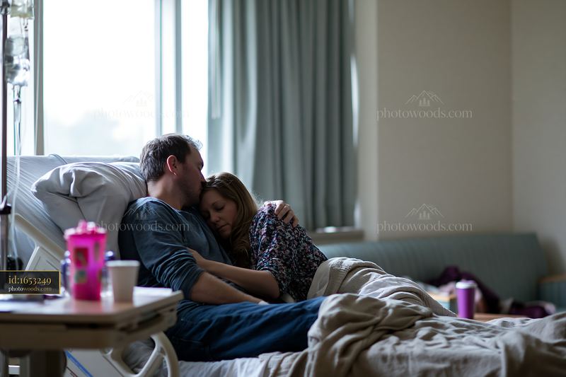 Kiss on forehead between partners in a hospital room