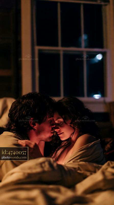 Kiss on forehead between partners in cozy indoor setting