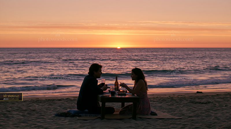 Couple enjoying a romantic sushi dinner by the beach at sunset