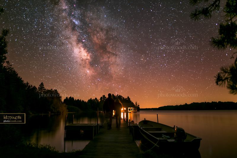 Couple on a dock beneath the Milky Way at night