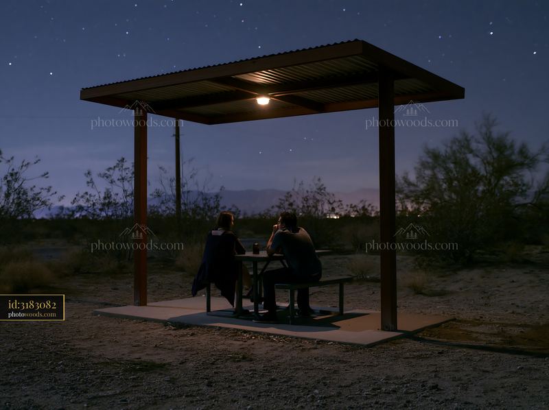 Couple stargazing in a desert at night under a shelter
