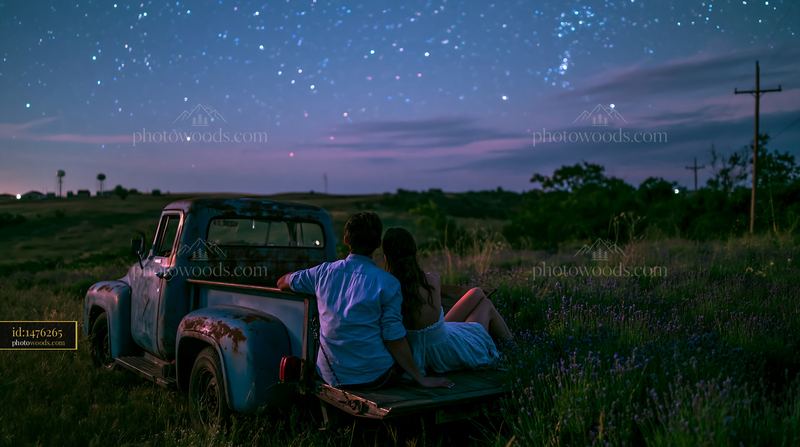 Couple sits on a truck under stars in a lavender field